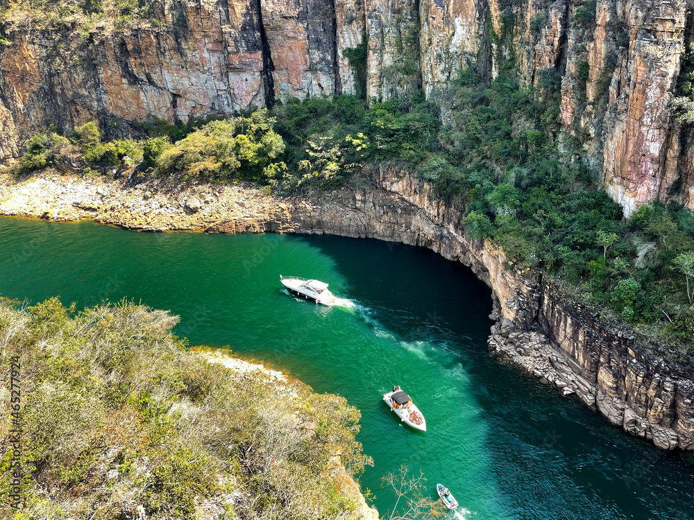 Canyon view from top, green water and three boats, high rock cliffs, sunny day in Capitolio MG Brasil -  Lago de Furnas