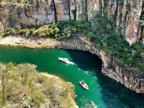 Canyon view from top, green water and three boats, high rock cliffs, sunny day in Capitolio MG Brasil -  Lago de Furnas © Gisela Fiuza