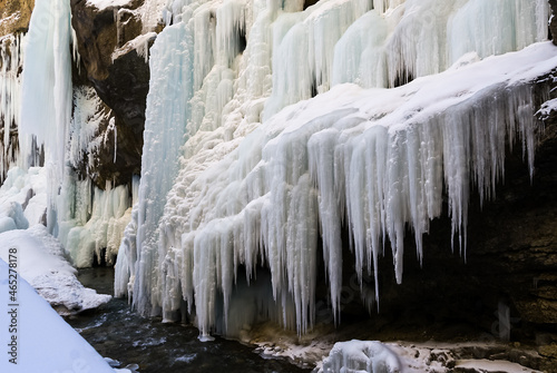 Frozen waterfall with huge beautiful icicles hanging from the rocks. Chegem waterfalls - majestic spectacle of extraordinary beauty in Kabardino-Balkaria  Russia