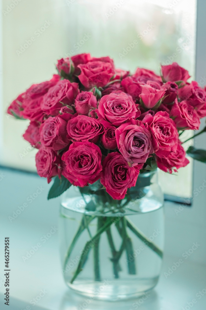 Obraz premium A chic bouquet of small pink roses in a jar on the windowsill. Cute still life 