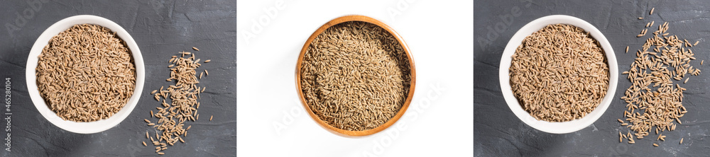 Set of spices cumin seeds (cuminum), jeera in white ceramic bowl on black concrete background, wooden bowl on white