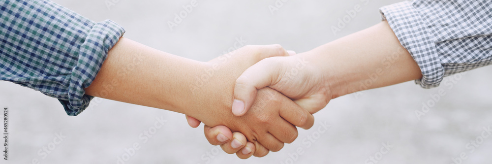 Closeup of a business hand shake between two colleagues Plaid shirt Closeup of a business hand shake between two colleagues Plaid shirt