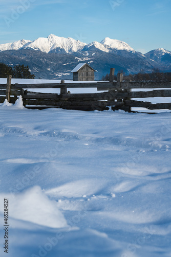 Selective focus on snow covered shed in winter landscape with view on the alpine mountain 'Hohe Munde', Mieming, Tirol, Austria