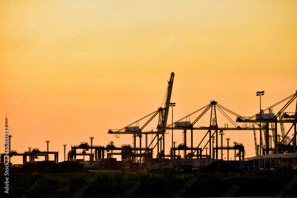 Silhouette photo during sunset, building construction in Laem Chabang deep sea port, Thailand.