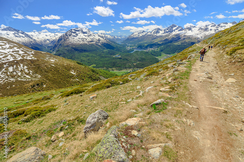 Swiss people trekking in on the mountain trail of Muottas Muragl in Switzerland. Popular mountain excursion in the snow in Grisons canton of Switzerland.