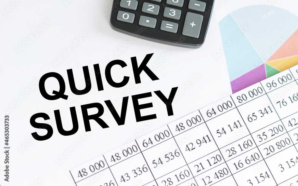 Quick Survey on notepad on table among reports, business concept Quick Survey on notepad on table among reports, business concept