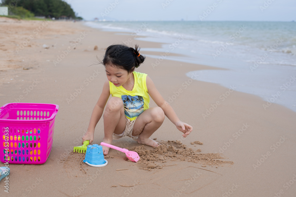 A young girl playing sand at the beach A young girl playing sand at the beach