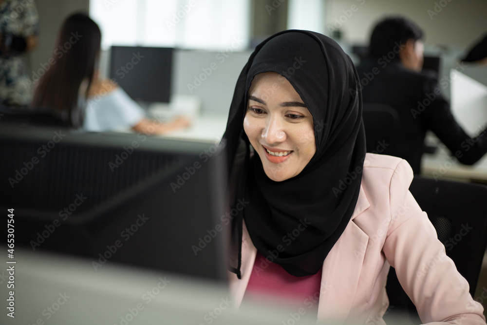 Happy muslim asian woman working and using pc at office meeting Happy muslim asian woman working and using pc at office meeting