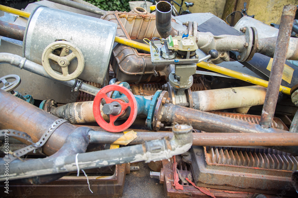 Special waste or valuable resources: Old rusty components of a heating boiler as pipes, counters, electric parts or control elements ready for removal or metal, cast iron and aluminium recycling
