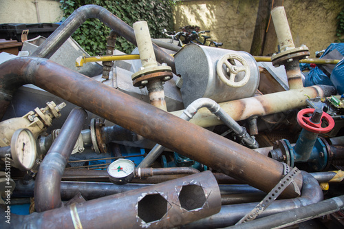 Special waste or valuable resources: Old rusty components of a heating boiler as pipes, counters, electric parts or control elements ready for removal or metal, cast iron and aluminium recycling