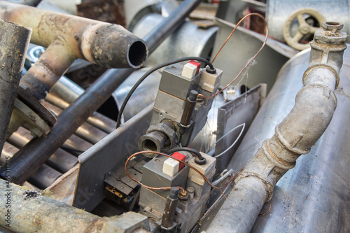 Special waste or valuable resources: Old rusty components of a heating boiler as pipes, counters, electric parts or control elements ready for removal or metal, cast iron and aluminium recycling