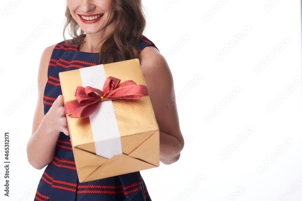 Close-up of smiling woman in stripped dress giving New Year present to camera, white background Close-up of smiling woman in stripped dress giving New Year present to camera, white background