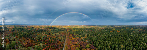 Panoramic full double rainbow of a autumn colored forest with the view at the bavarian skyline of Munich in the background. photo