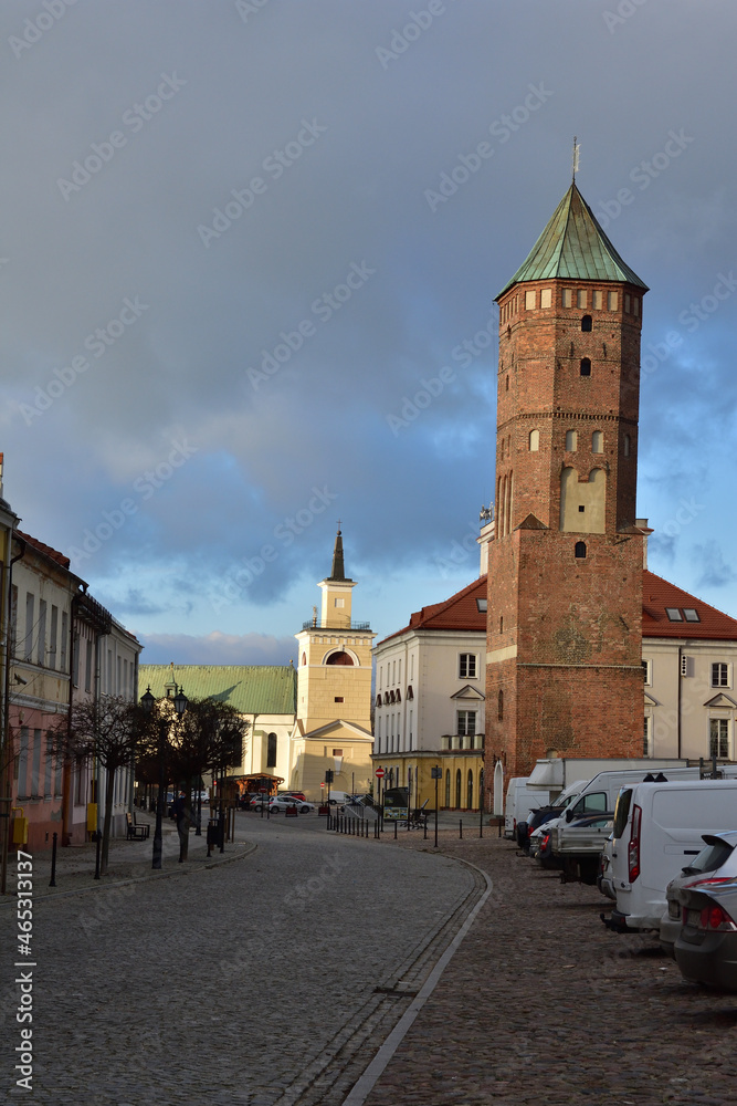 Obraz premium The historic, paved market square in Pułtusk and the basilica in the background. Pułtusk. Autumn.