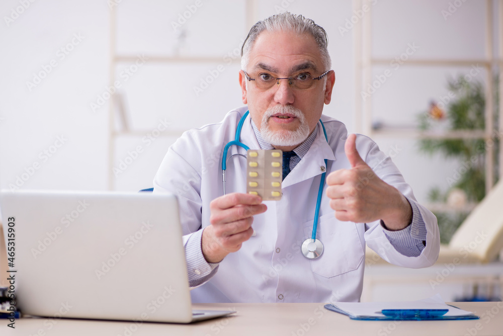Old male doctor working in the clinic Old male doctor working in the clinic