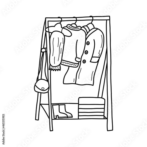 Modern wooden floor rack for clothes, rail. The bag hangs on the side. Coat, scarf and warm sweater. There are shoes and a box on the shelf. Black and white vector isolated illustration doodle