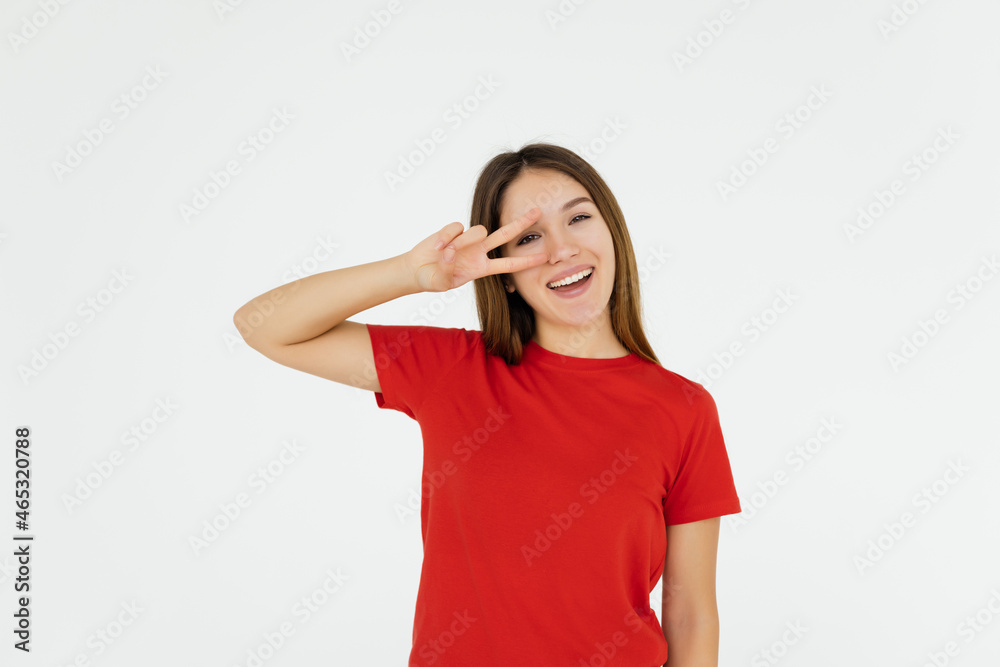 Portrait of a smiling young asian woman taking a selfie and showing peace gesture over white background Portrait of a smiling young asian woman taking a selfie and showing peace gesture over white background