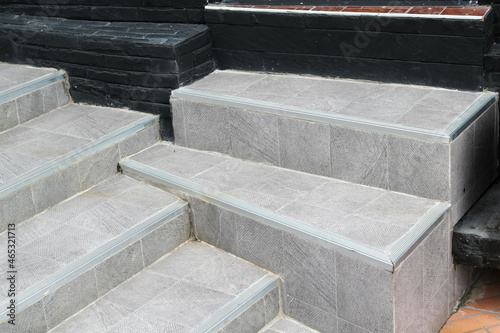The outdoor staircase covered with grey ceramic tiles.