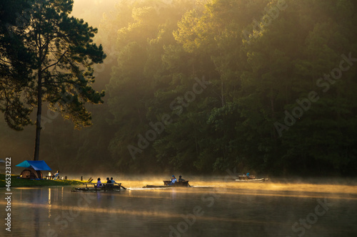 The beautiful morning with sunlight pierce through the forest with morning fog over water at PangUng Lake in Mae Hong Son, north of Thailand.