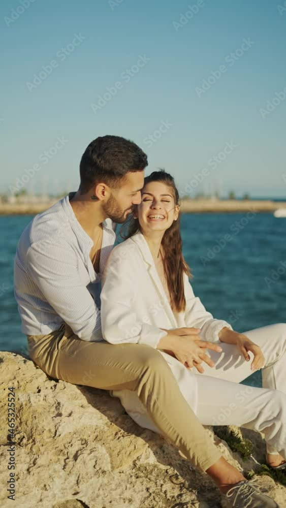 Content ethnic couple conversing on mountain against sea