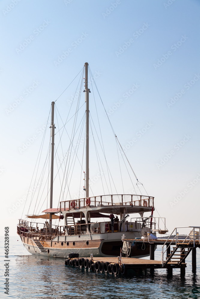 Vintage mast wooden sailing ship for sea tours. Touristic pirate ship in port. Marina in in resort city Kemer, Turkey. Old harbour in Turkey