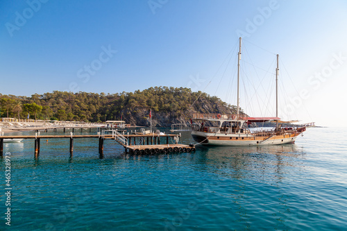 Vintage mast wooden sailing ship for sea tours. Touristic pirate ship in port. Marina in in resort city Kemer, Turkey. Old harbour in Turkey © Aleksandr Kondratov