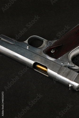 Automatic white gun stainless steel pistol weapon model m1911 with real bullet ammo head in black background photo