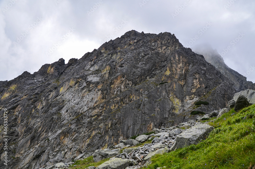 Amazing natural landscape with stones with rocks in fog and cloudy sky in the misty summer day. Mountain peaks in the Tatra Mountains, Slovakia