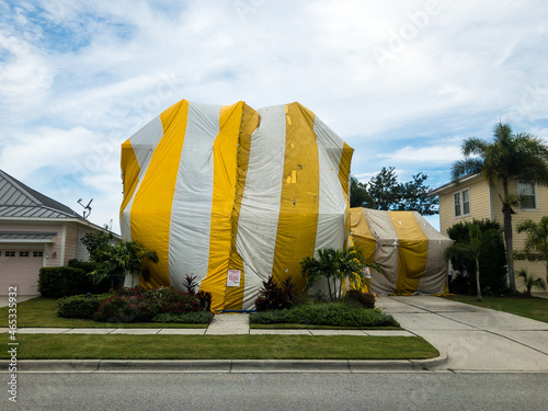 Florida Home Covered with a Yellow and White Tent While being Fumigated for Termites photo