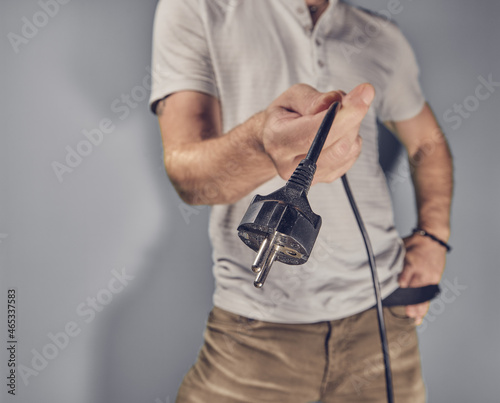 Man holding electricity plug in hand