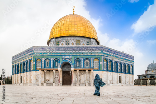 The Dome of the Rock and a Mosque in the Old City of Jerusalem with a one young Arabian women passing in front, Israel. Kippat Ha Sela in Jerusalem.