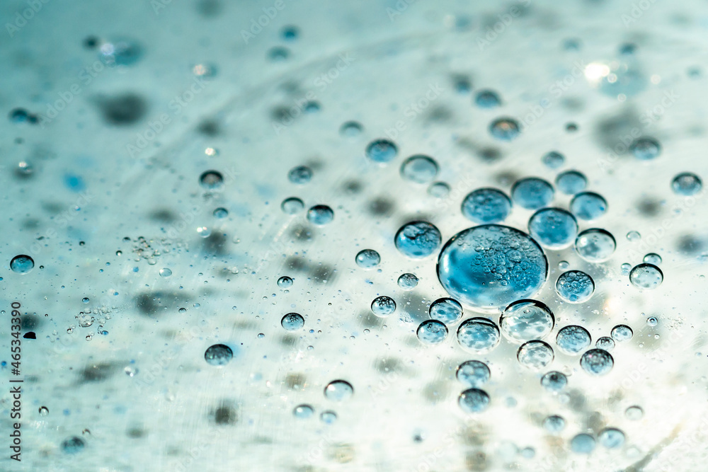 White and blue waterdrops swimming on a oil surface White and blue waterdrops swimming on a oil surface