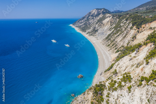 Lefkada, Greece. Remote white Egremni beach with lonely luxury yacht boat on the turquoise colored bay on Ionian Sea