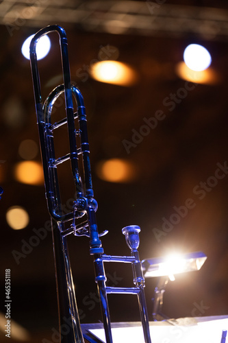 Photography A trombone with a mouthpiece backlit from a music stand light