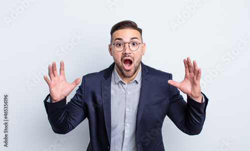 young handsome man screaming with hands up in the air. businessman concept