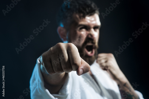 Bearded man do karate training. Brutal bearded boxer, ready to fight. Boxing, workout, muscle, strength, power - sport concept. Selective focus on fist.