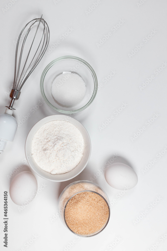 Ingredients and utensils for baking on a white background.