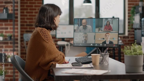 Entrepreneur using video call on computer to talk to colleagues about marketing strategy. Employee attending business meeting with workmates, talking about presentation and project photo