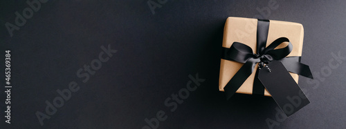 Black Friday banner with gift box on black background.