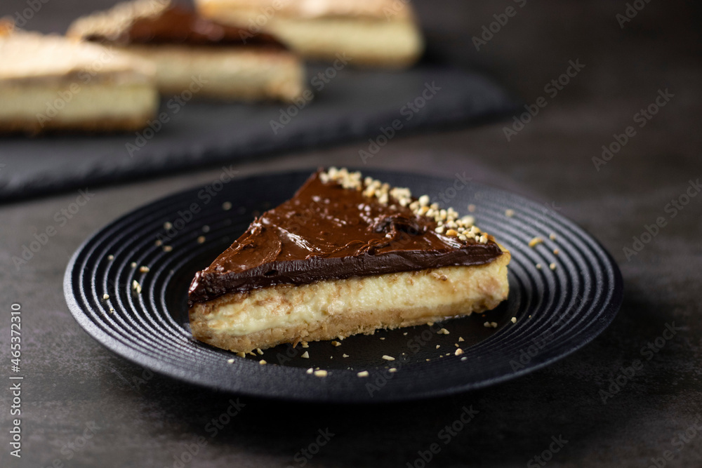Chocolate Cheesecake with walnuts on black plate