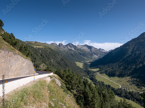 asphalt road and hiking trail entering into a mountain valley