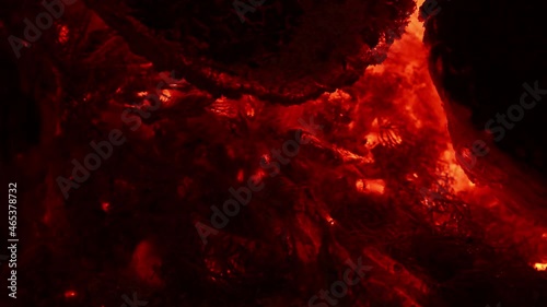 Incandescent orange and red embers texture. Contains the sound of crackling and chirping crickets. Side view. 4K UHD video footage 3840X2160