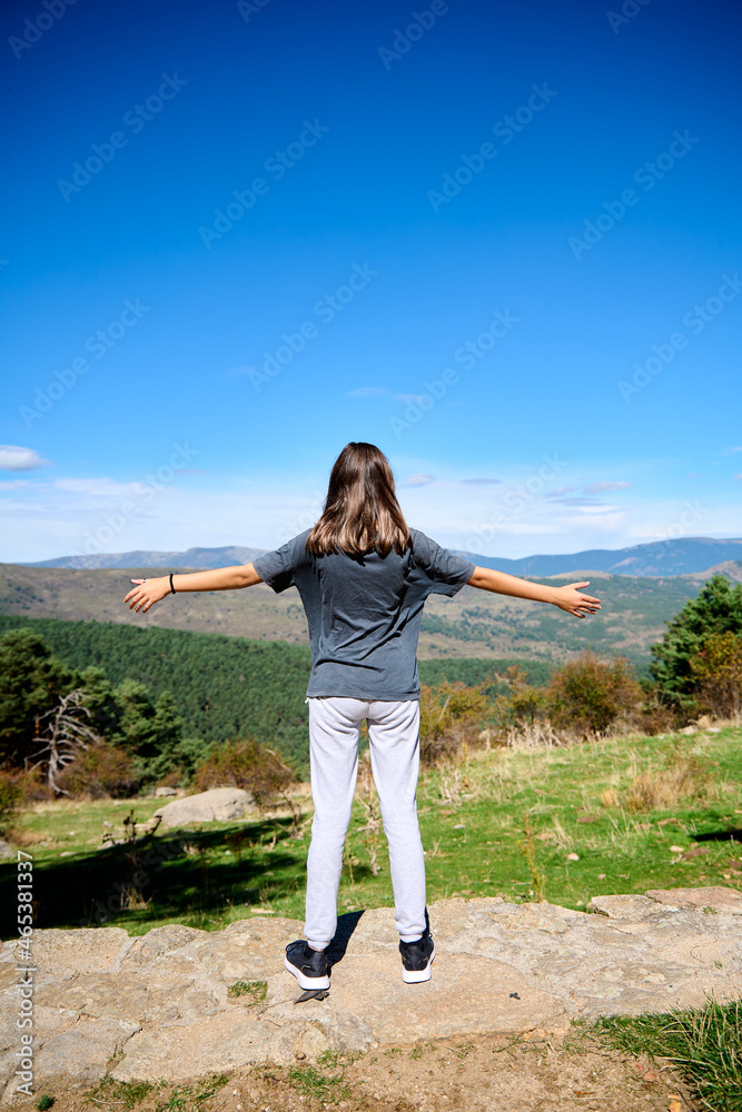 Girl standing on the viewpoint and looking at the green landscapes on a sunny day Girl standing on the viewpoint and looking at the green landscapes on a sunny day