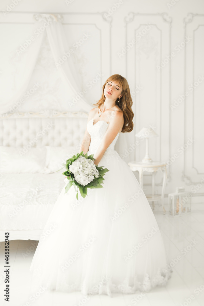 Luxury bride in white dress posing while preparing for the wedding ceremony Luxury bride in white dress posing while preparing for the wedding ceremony