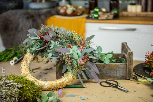 Adventskranz mit Eukalyptus, Mimose und roten Beeren - Weihnachtskranz photo