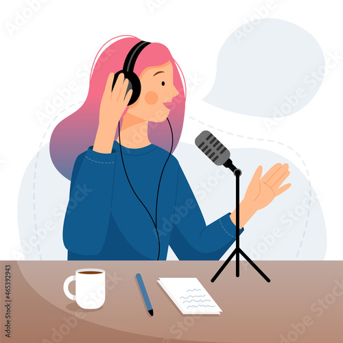 Podcast concept. Cute woman in headphones speaks into the microphone. The girl recording audio broadcast. 