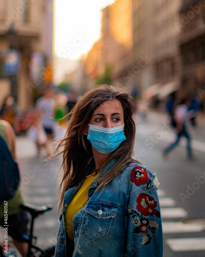 Beauty girl looking at nowhere with blue covid mask and a flowers jacket