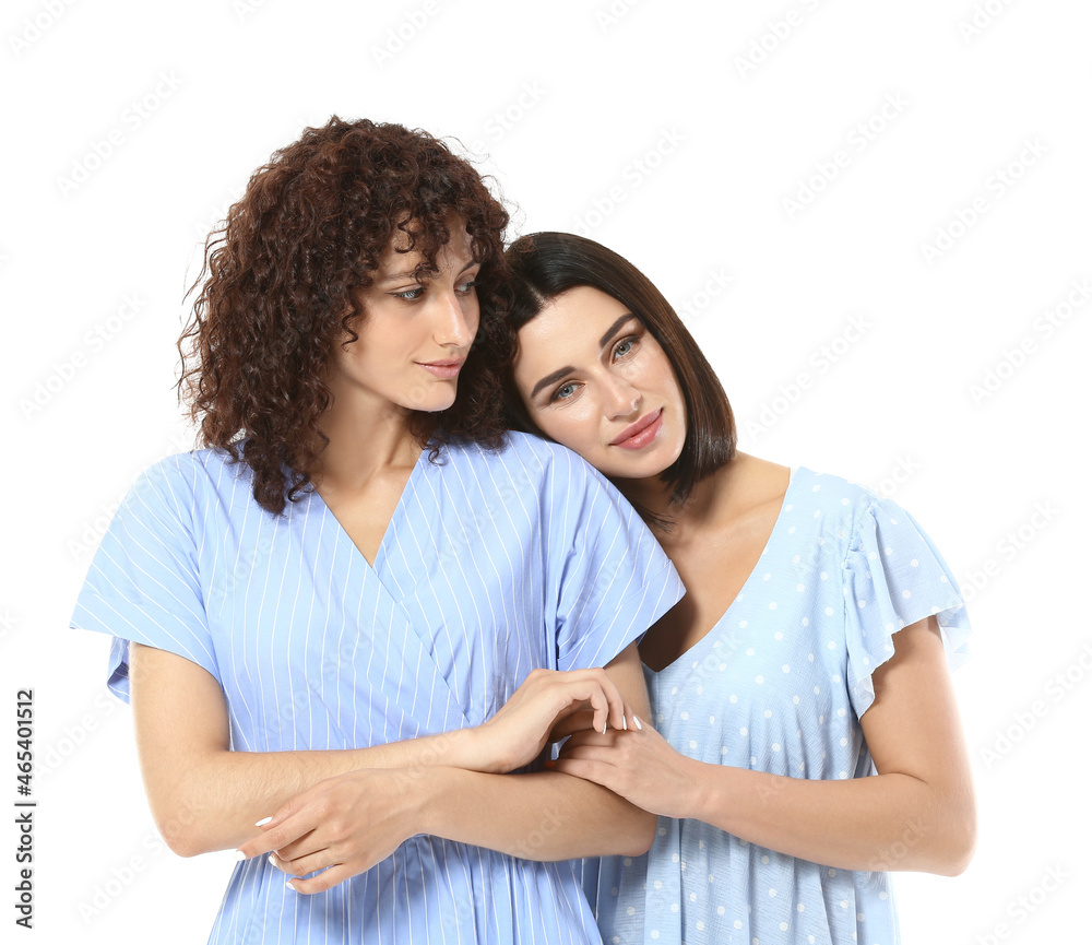 Beautiful sisters hugging on white background Beautiful sisters hugging on white background