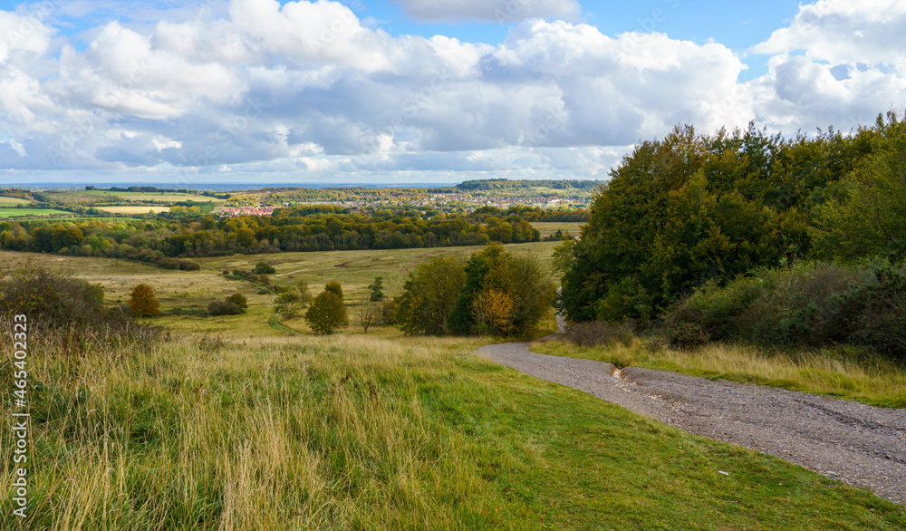 a view over woodland and meadows to North Tidworth from Sidbury Hill, WIltshire (Historical landmark) under a blue and white cloud sky