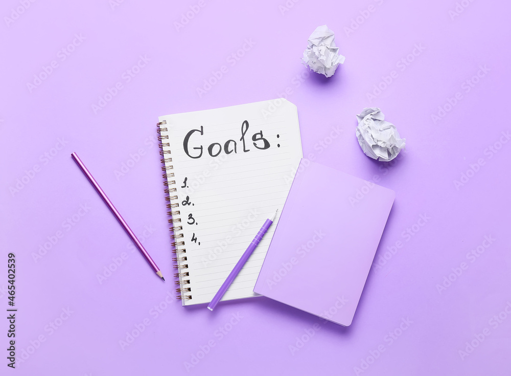 Notebook with empty to do list and stationery on color background. New year goals Notebook with empty to do list and stationery on color background. New year goals